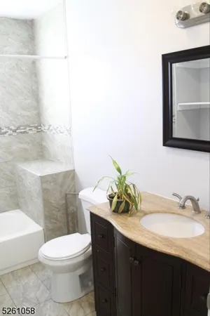 a bathroom with a granite countertop sink and a toilet