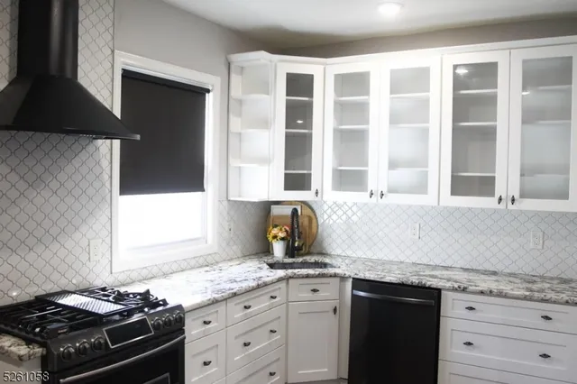 a kitchen with granite countertop a stove and a sink