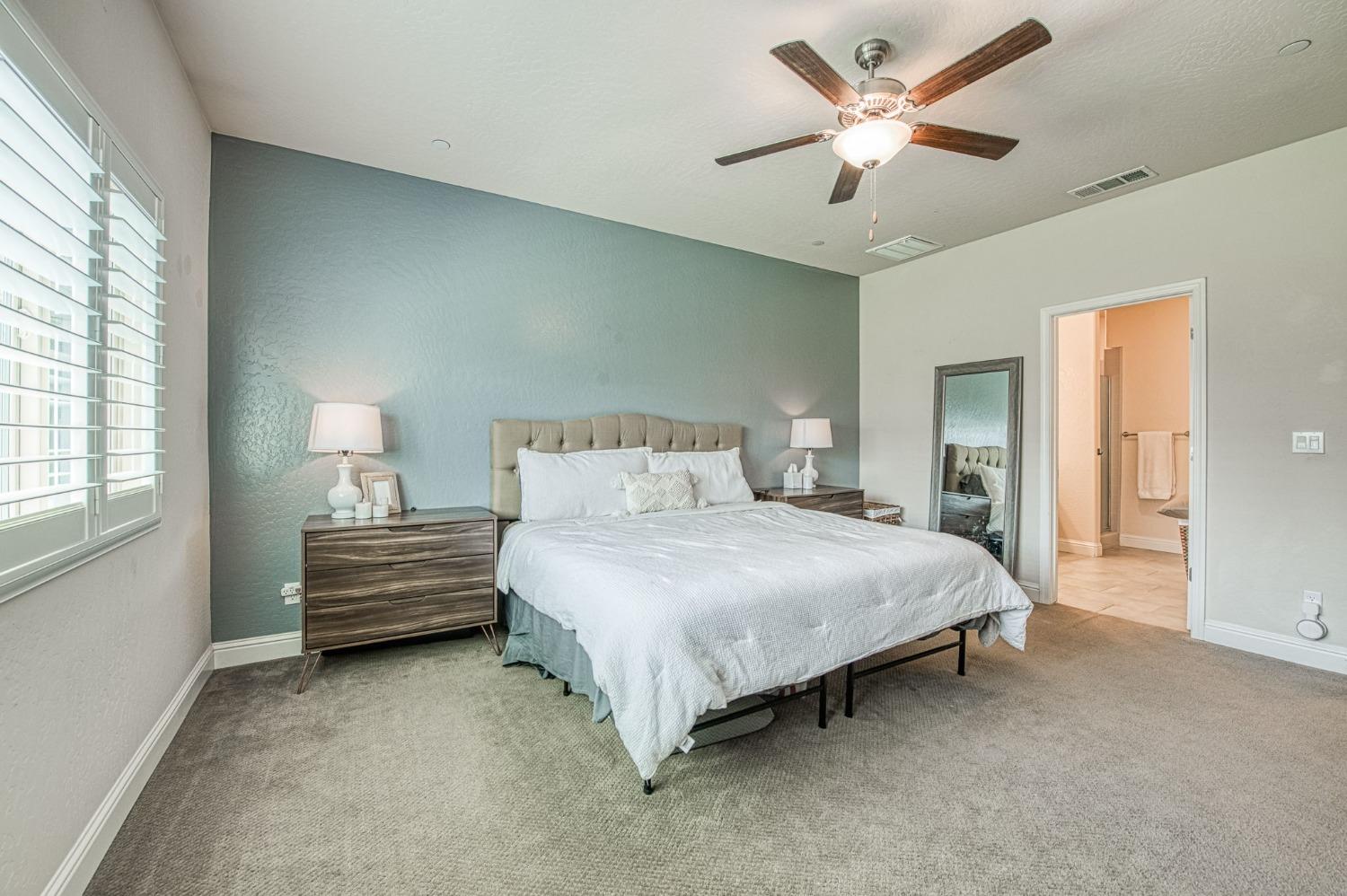 574 Expedition Way Madera, CA 93636 - Photo 19 of 26 a bedroom with a bed chandelier and a window