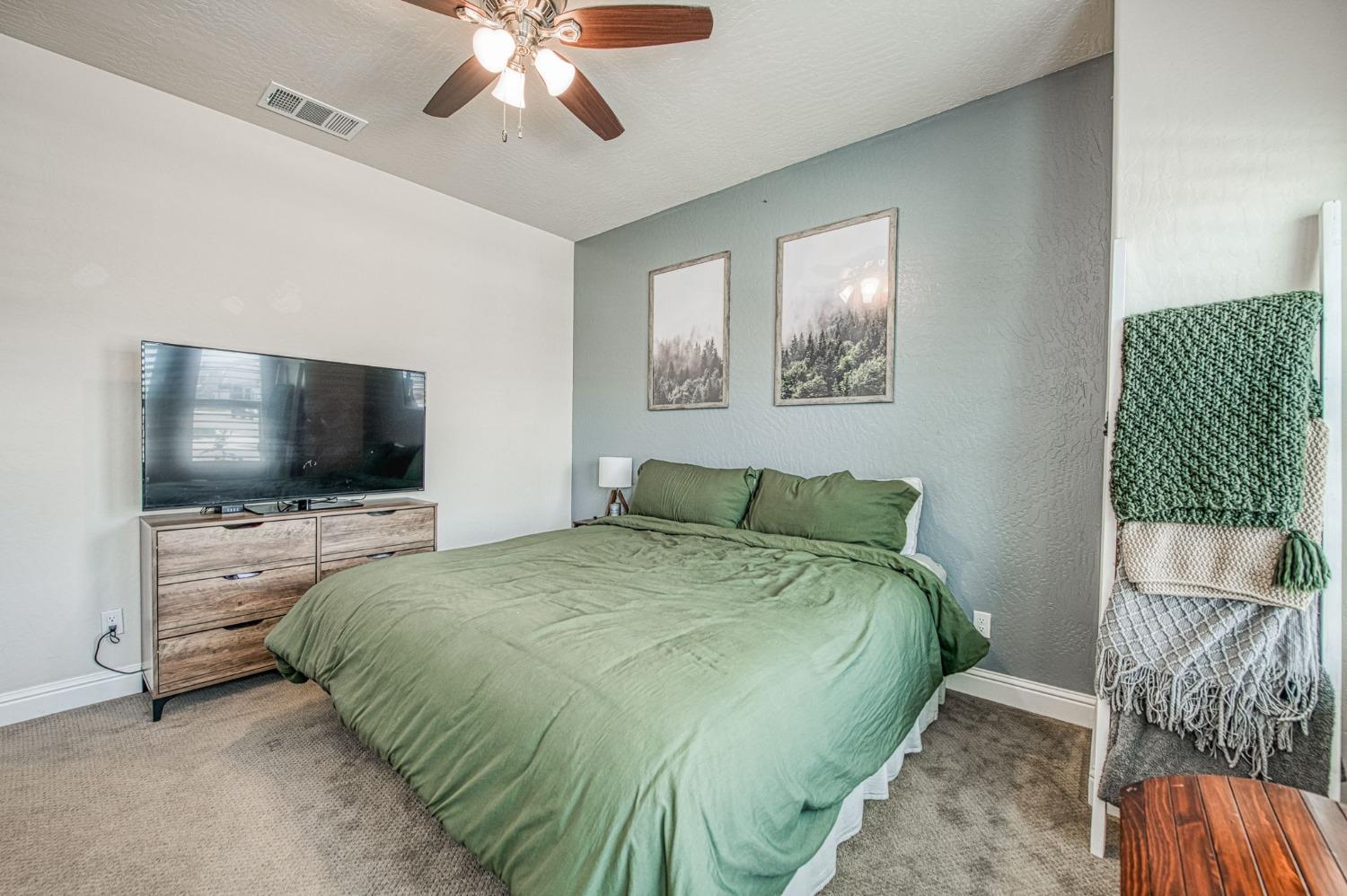 574 Expedition Way Madera, CA 93636 - Photo 5 of 26 a bedroom with a bed and a flat screen tv