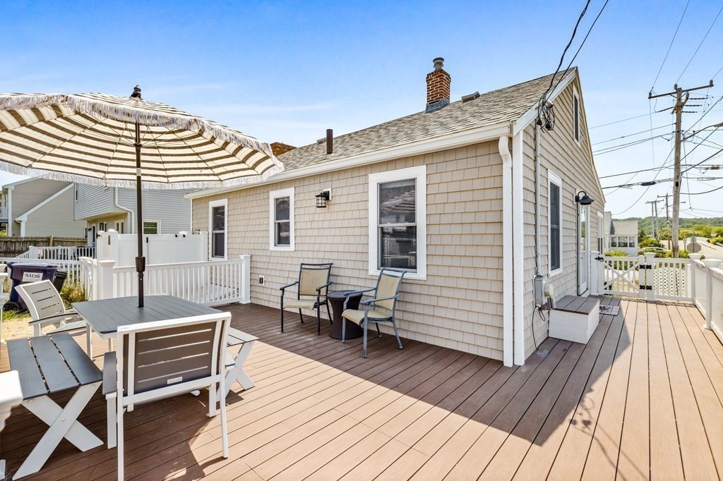 95 River Street Scituate, MA 02066 - Photo 13 of 23 a front view of a house with barbeque oven table and chairs