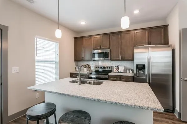 a kitchen with kitchen island a sink refrigerator and microwave