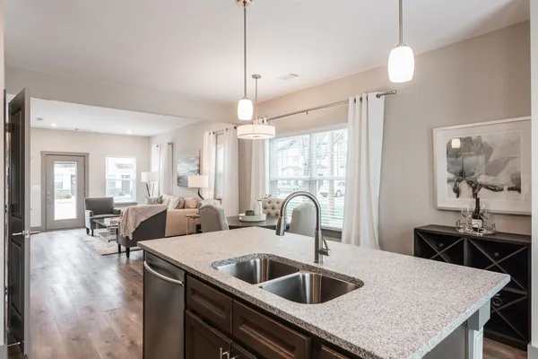 a kitchen with sink refrigerator and living room view