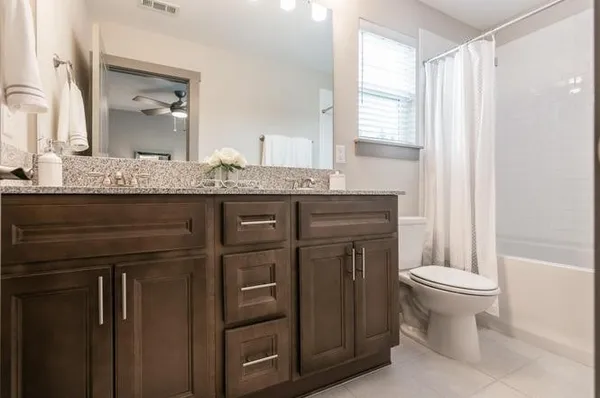 a bathroom with a granite countertop toilet sink and mirror