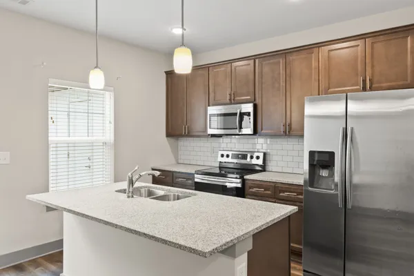 a kitchen with stainless steel appliances wooden cabinets a sink and a stove