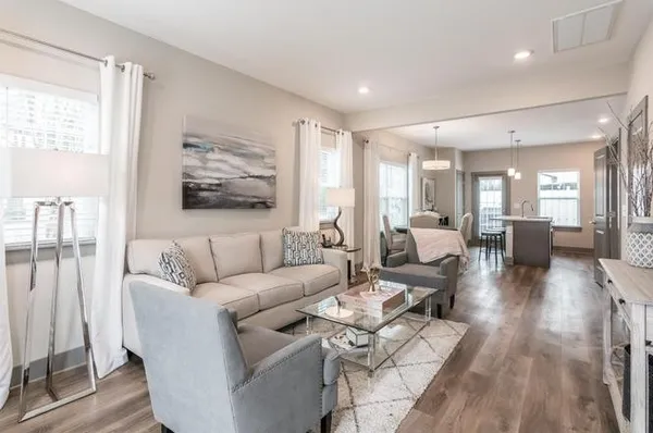 a living room with furniture wooden floor and a large window