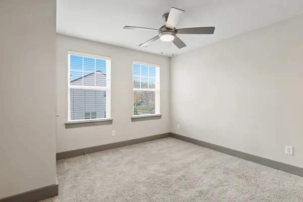 an empty room with chandelier fan