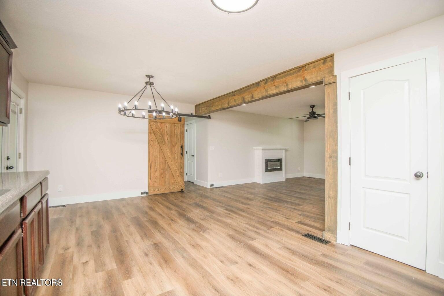 589 Possum Valley Road Maynardville, TN 37807 - Photo 15 of 49 a view of a livingroom with wooden floor and a ceiling fan