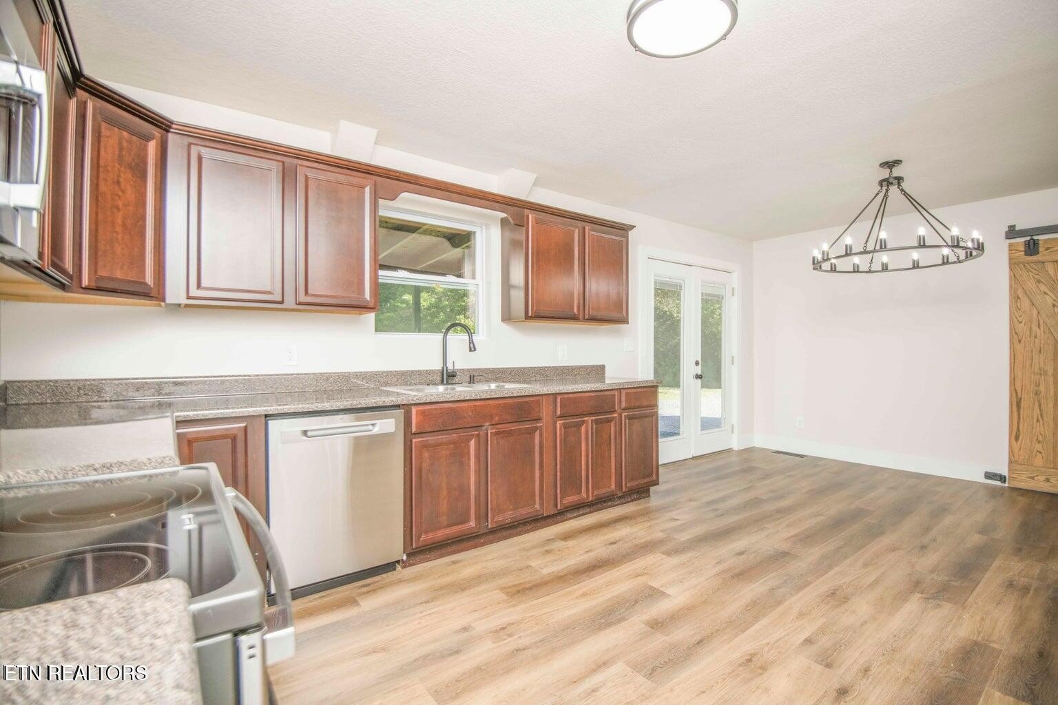 589 Possum Valley Road Maynardville, TN 37807 - Photo 16 of 49 a kitchen with stainless steel appliances granite countertop a sink a stove cabinets and wooden floor