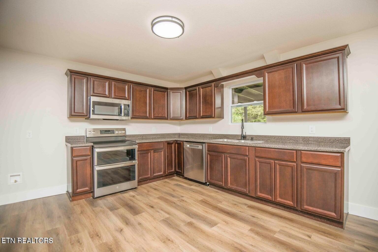589 Possum Valley Road Maynardville, TN 37807 - Photo 19 of 49 a kitchen with stainless steel appliances granite countertop a stove a sink and a microwave