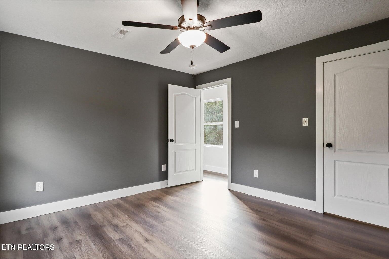 589 Possum Valley Road Maynardville, TN 37807 - Photo 30 of 49 an empty room with wooden floor and ceiling fan