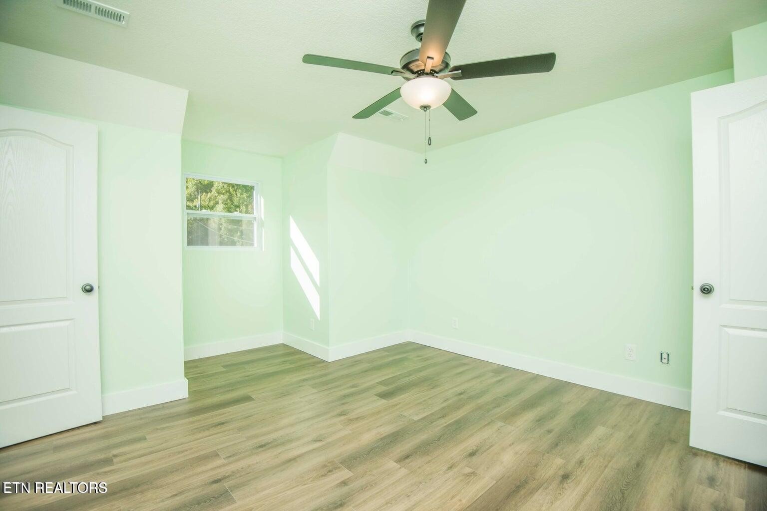 589 Possum Valley Road Maynardville, TN 37807 - Photo 37 of 49 a view of a room with wooden floor and a ceiling fan