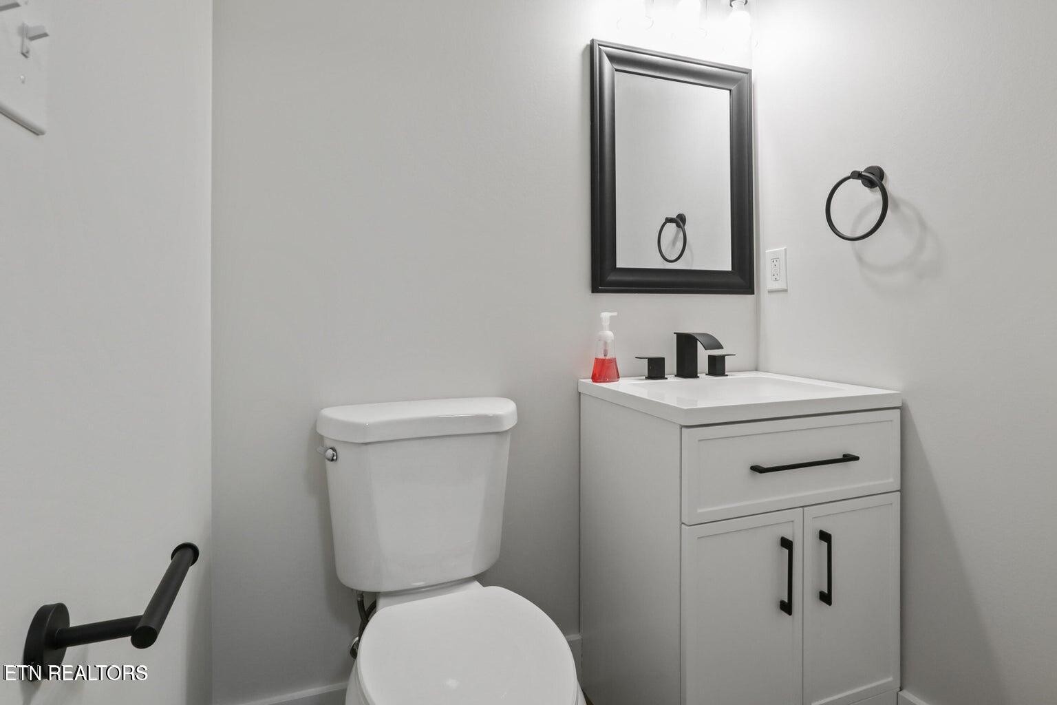 589 Possum Valley Road Maynardville, TN 37807 - Photo 38 of 49 a bathroom with a toilet sink vanity and mirror