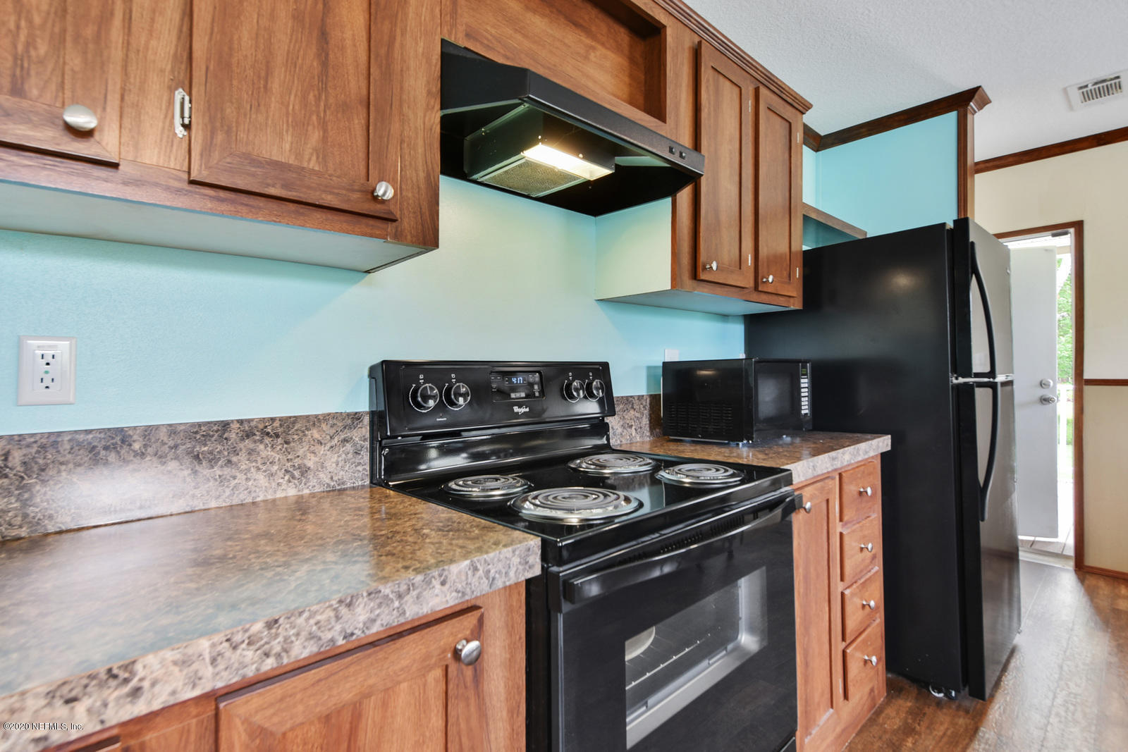 54464 Sherwood Road Callahan, FL 32011 - Photo 11 of 25 a kitchen with stainless steel appliances granite countertop a stove a refrigerator and a microwave
