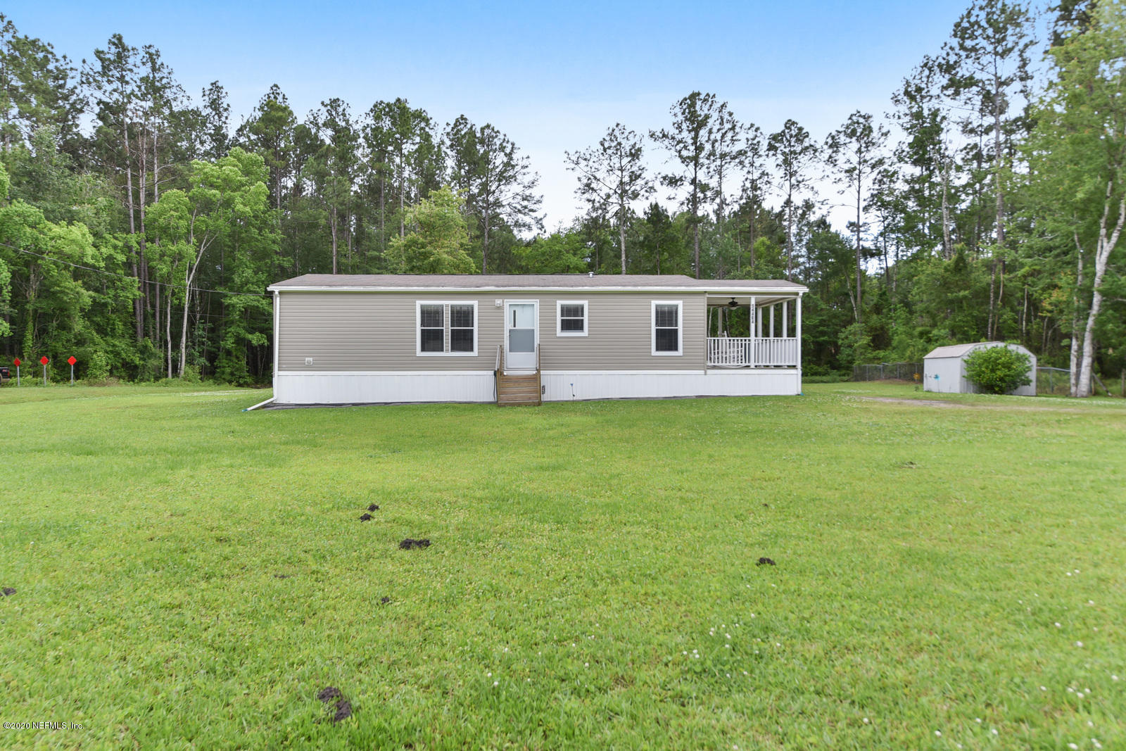 54464 Sherwood Road Callahan, FL 32011 - Photo 2 of 25 a front view of house with yard and trees in the background