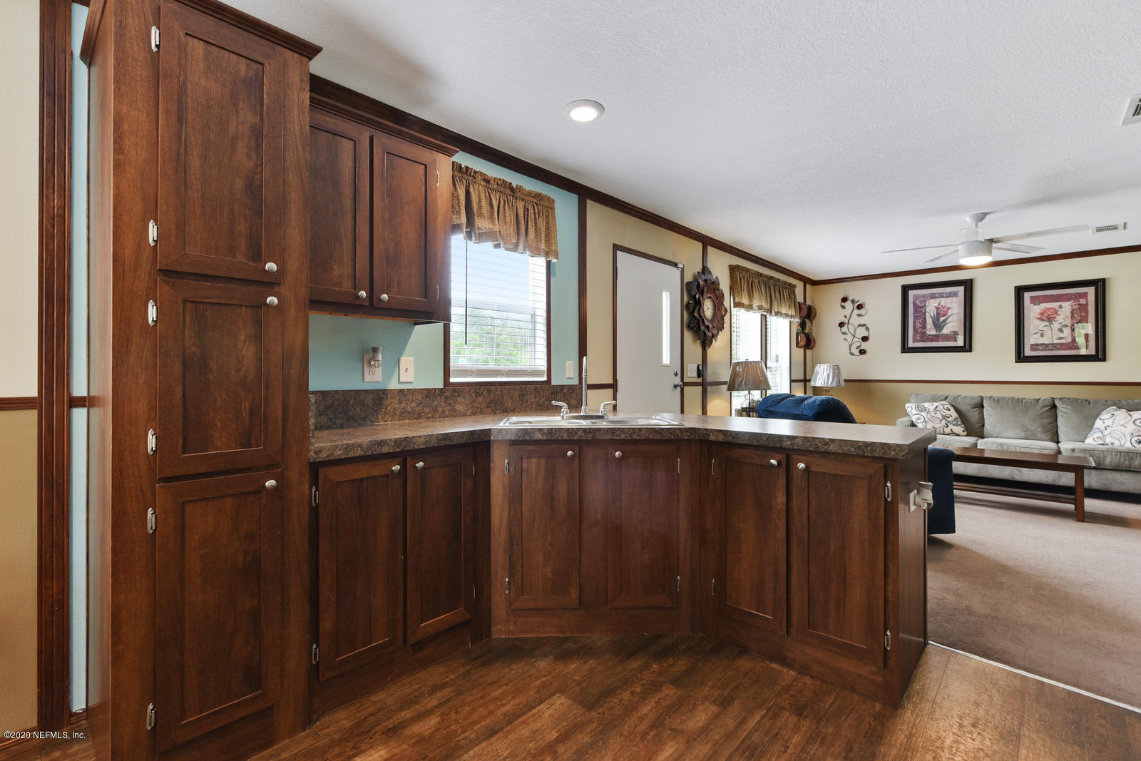54464 Sherwood Road Callahan, FL 32011 - Photo 9 of 25 a kitchen with granite countertop a refrigerator and wooden cabinets