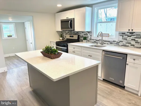 a kitchen with a sink a stove top oven a counter space and cabinets