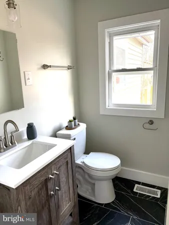 a bathroom with a double vanity sink toilet and a mirror