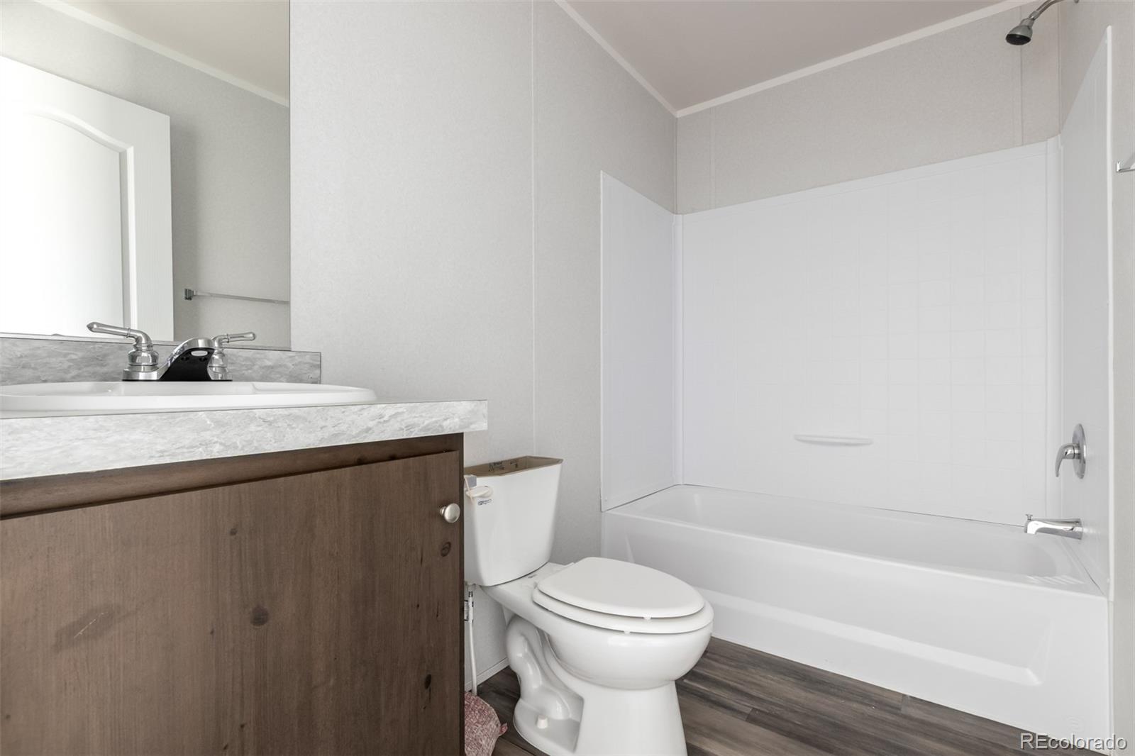 105 Longs Street Brighton, CO 80601 - Photo 20 of 27 a bathroom with a granite countertop sink toilet mirror and bathtub