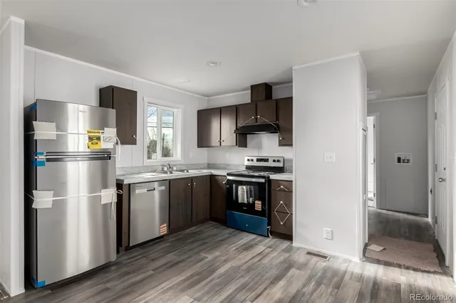 a view of a kitchen with a sink and dishwasher wooden floor