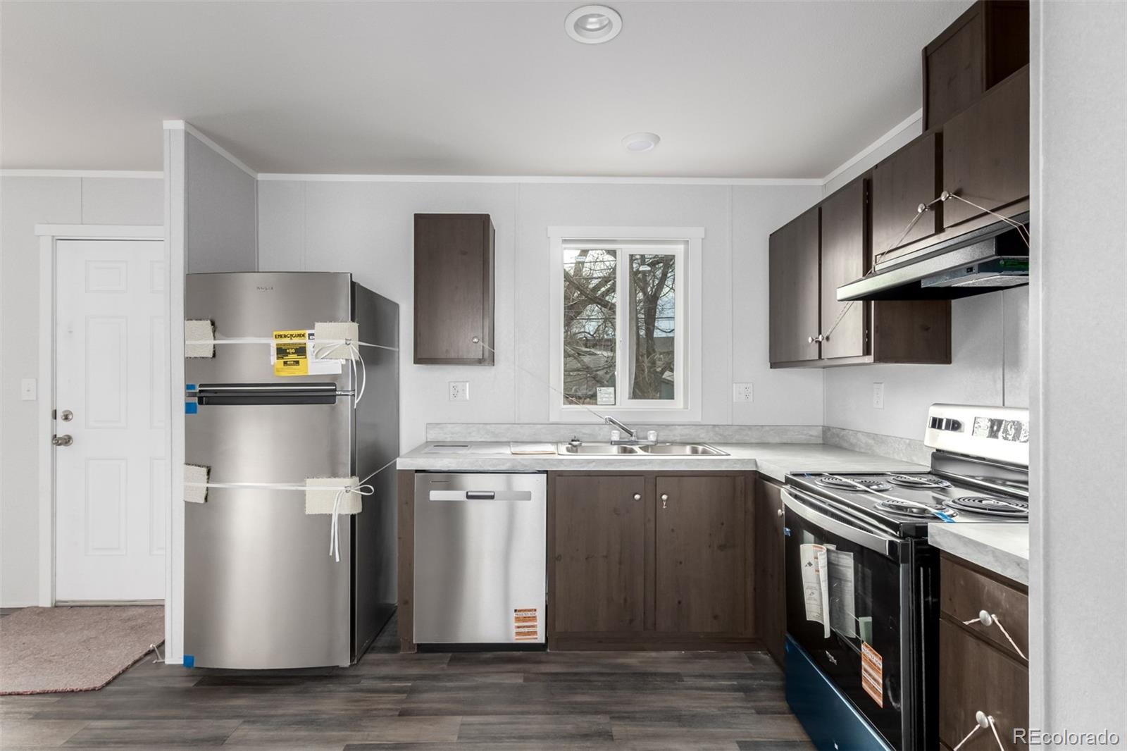 105 Longs Street Brighton, CO 80601 - Photo 8 of 27 a kitchen with stainless steel appliances granite countertop a stove top oven a sink and a refrigerator