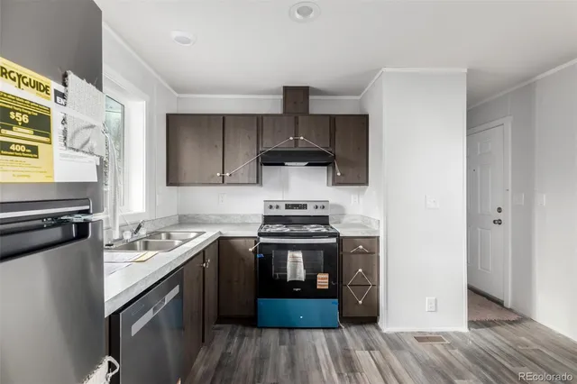 a view of a kitchen with wooden floor and a window