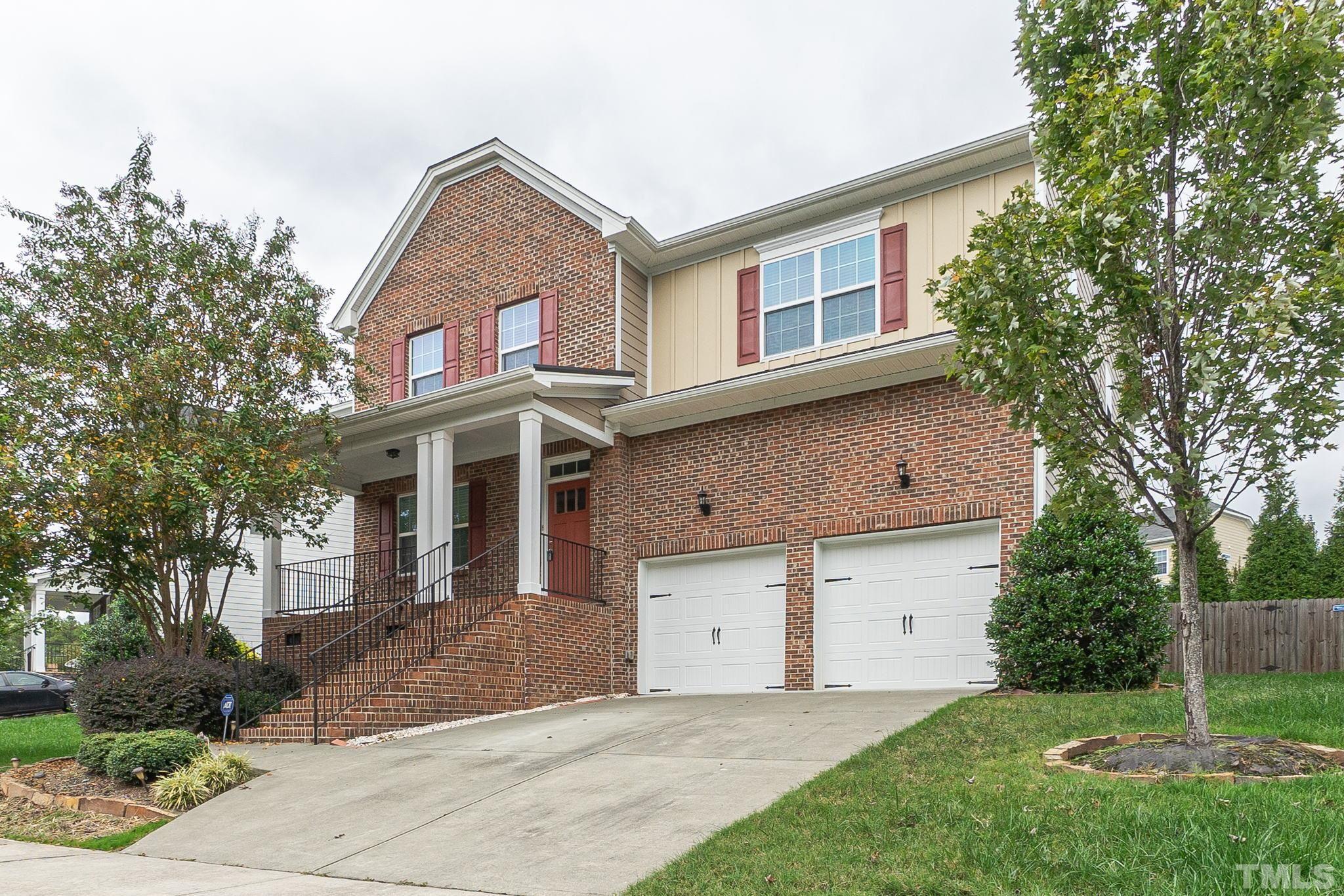 222 Strolling Way Durham, NC 27707 - Photo 2 of 26 a front view of a house with a garden and plants