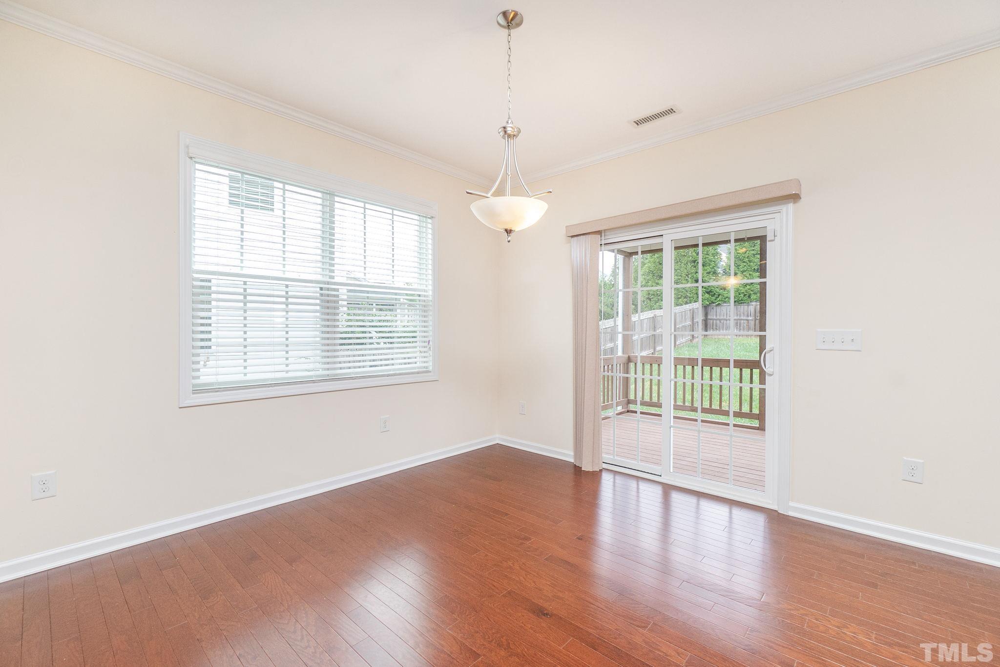 222 Strolling Way Durham, NC 27707 - Photo 11 of 26 a view of an empty room with wooden floor and a window