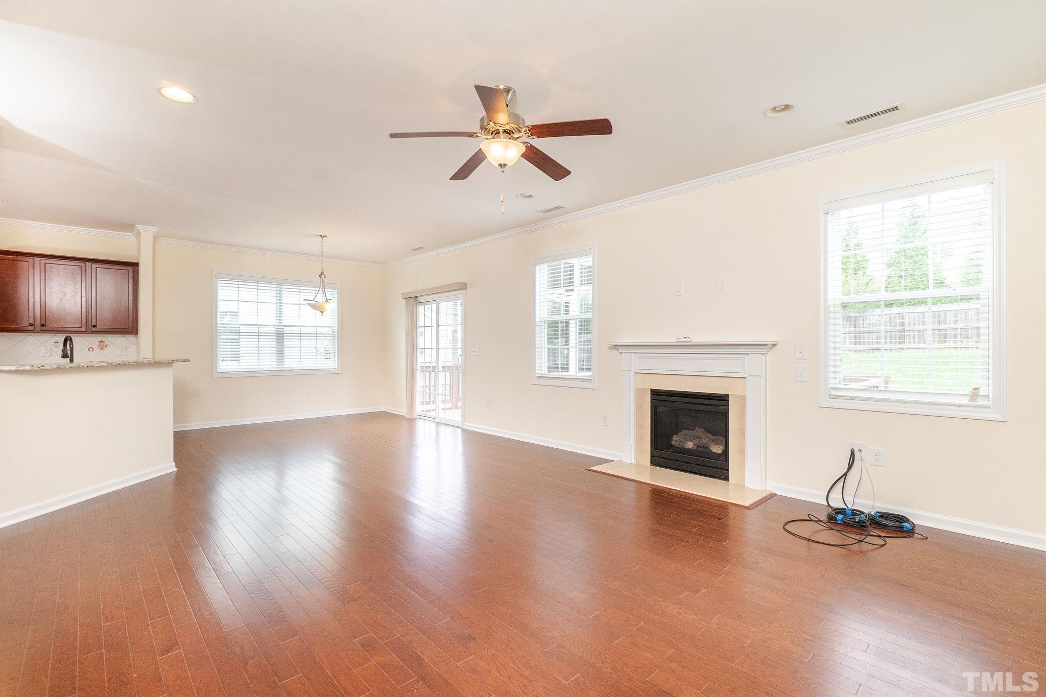 222 Strolling Way Durham, NC 27707 - Photo 14 of 26 a view of a livingroom with a fireplace a ceiling fan and wooden floor