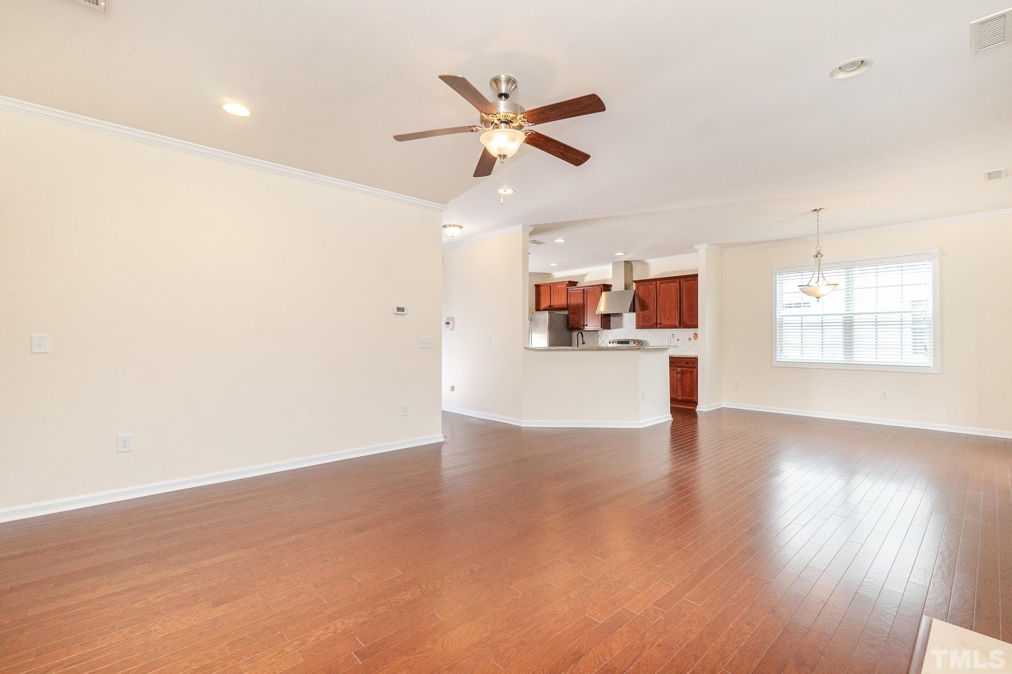 222 Strolling Way Durham, NC 27707 - Photo 15 of 26 a view of a livingroom with a ceiling fan and wooden floor