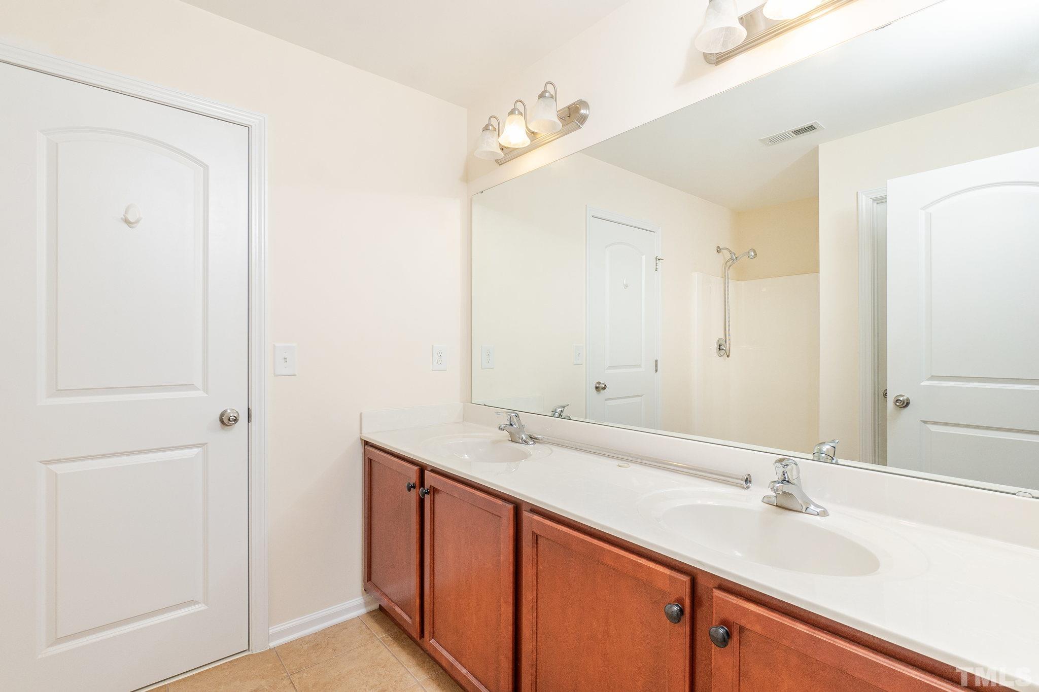 222 Strolling Way Durham, NC 27707 - Photo 22 of 26 a bathroom with a sink and a mirror