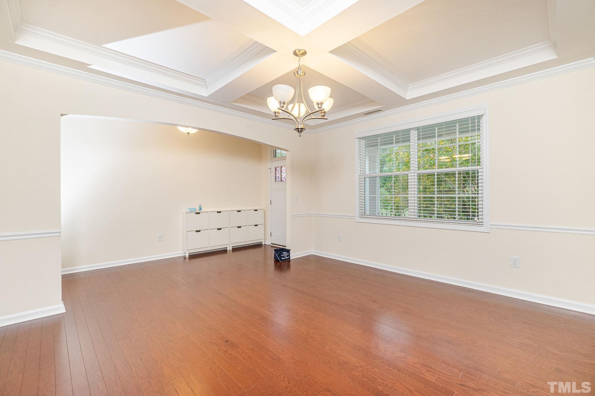 222 Strolling Way Durham, NC 27707 - Photo 6 of 26 an empty room with a chandelier fan and windows