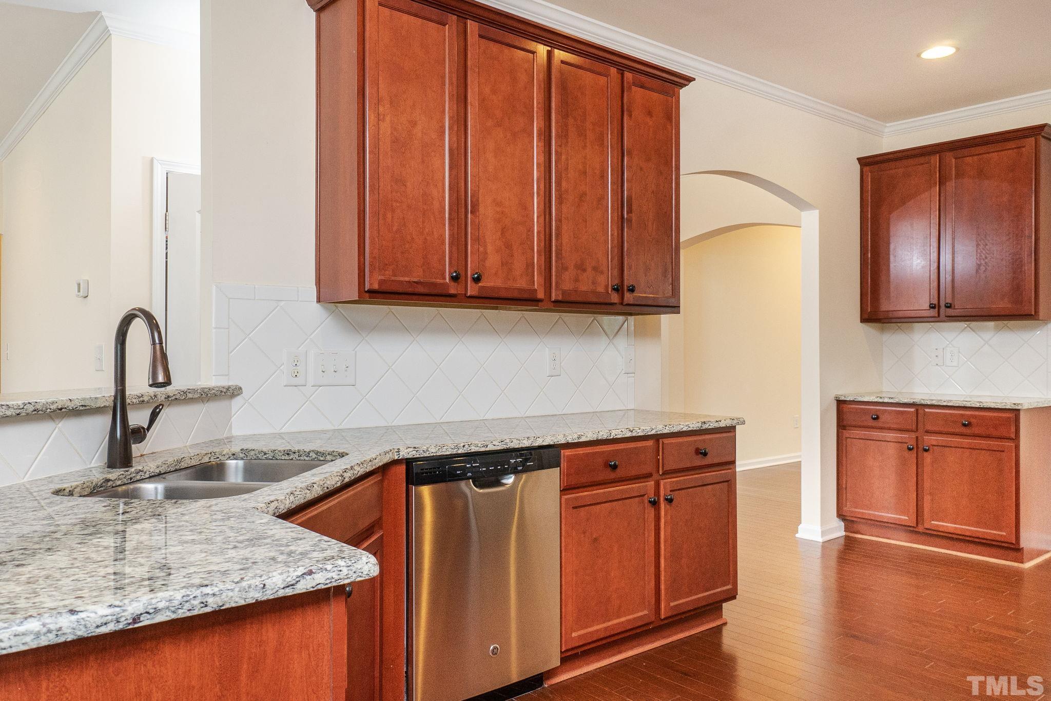 222 Strolling Way Durham, NC 27707 - Photo 9 of 26 a kitchen with wooden cabinets and a sink