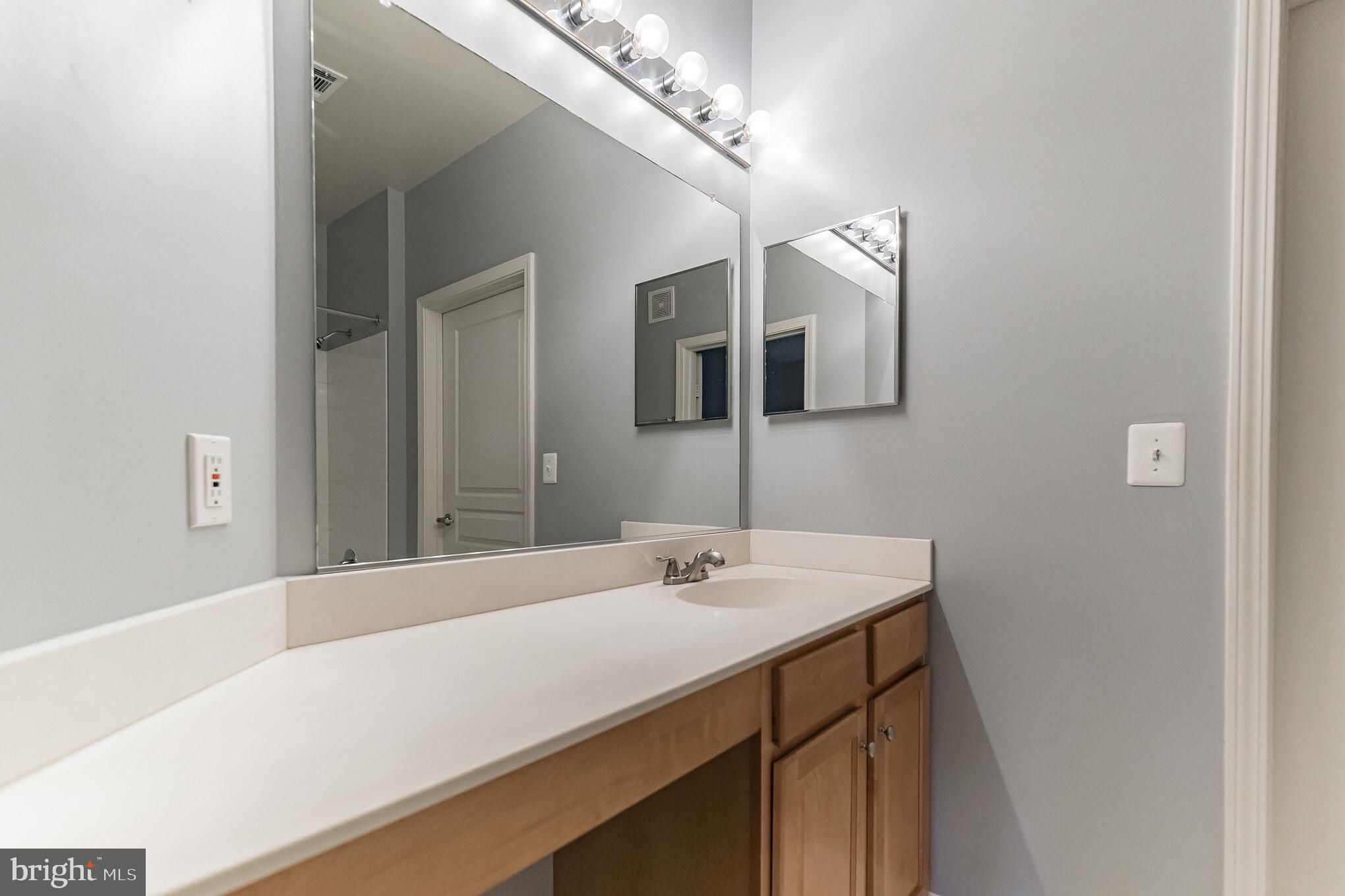 12001 Market Street, Unit 106 Reston, VA 20190 - Photo 17 of 26 a bathroom with a sink vanity and mirror