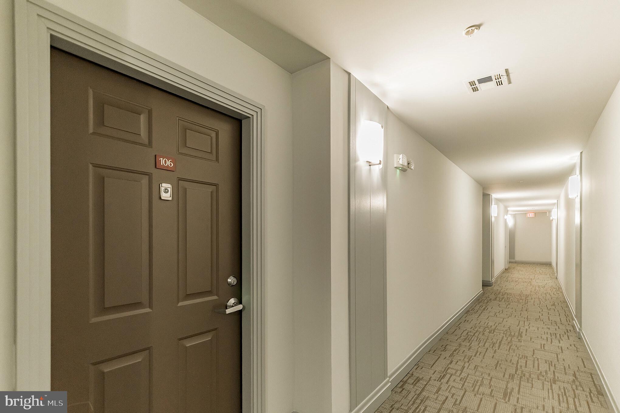 12001 Market Street, Unit 106 Reston, VA 20190 - Photo 3 of 26 a view of a hallway with wooden floor