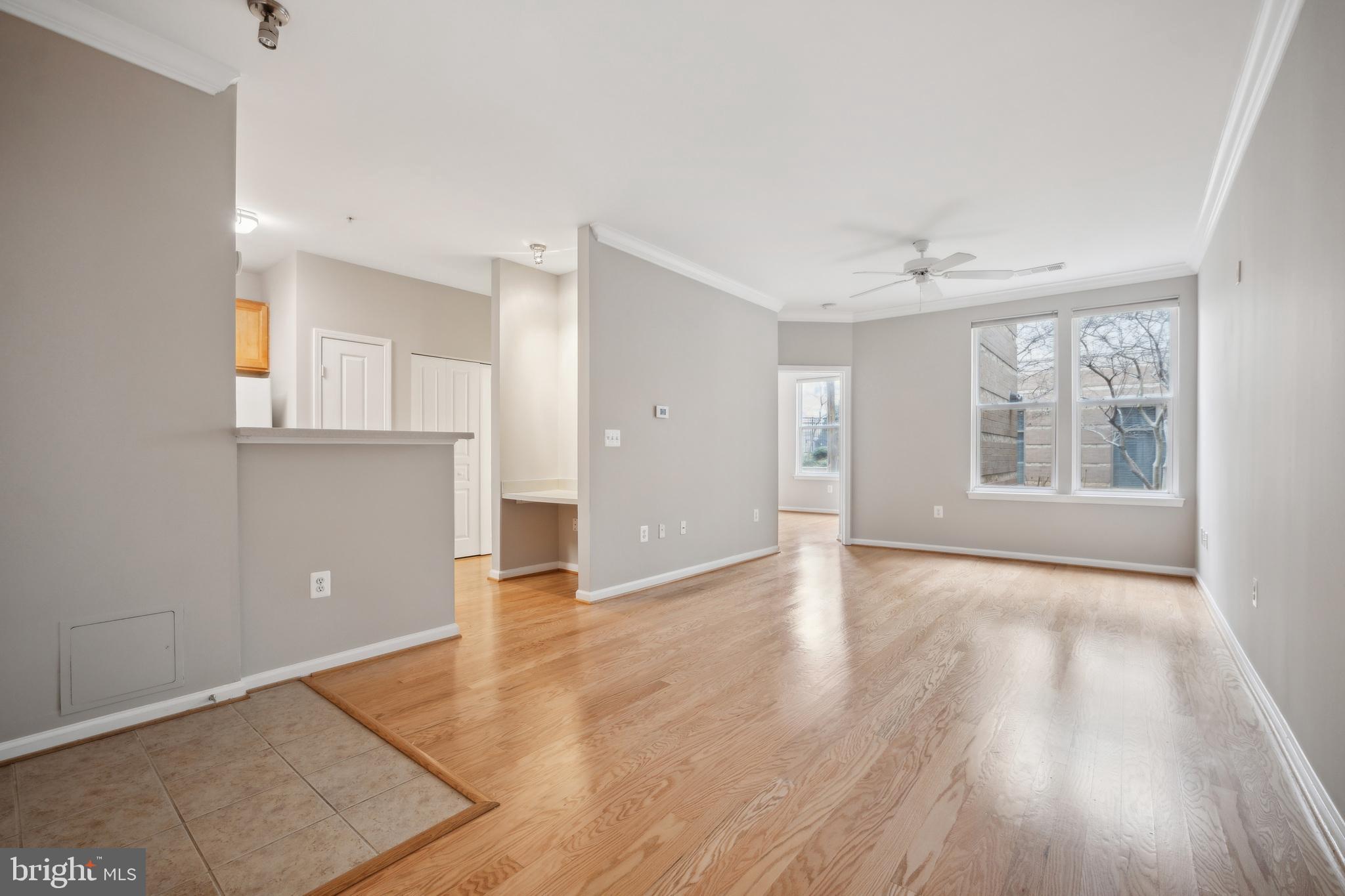 12001 Market Street, Unit 106 Reston, VA 20190 - Photo 5 of 26 an empty room with wooden floor and windows