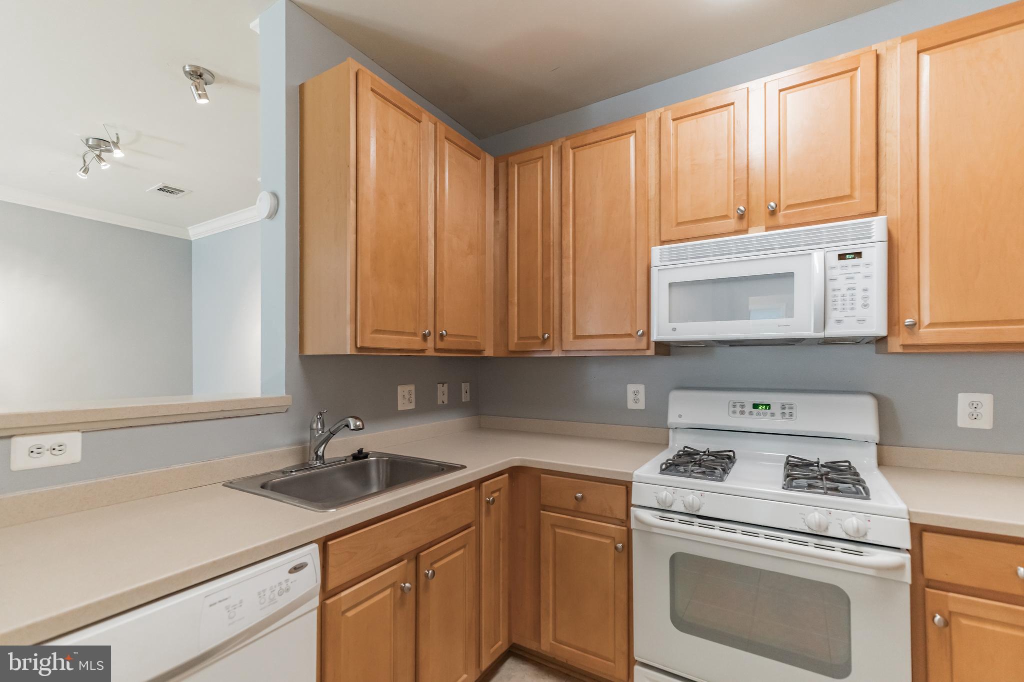 12001 Market Street, Unit 106 Reston, VA 20190 - Photo 9 of 26 a kitchen with appliances cabinets and a sink