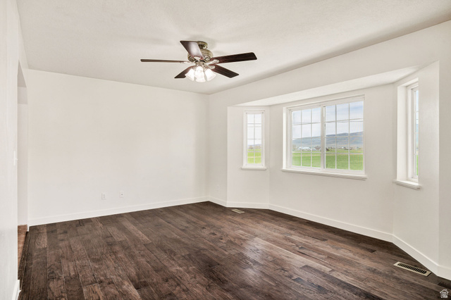 365 South Center Street Fielding, UT 84311 - Photo 6 of 41 Unfurnished room featuring dark wood-style floors and ceiling fan