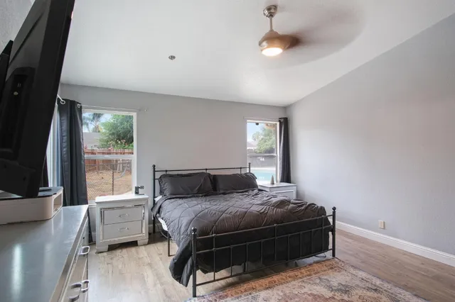 a bedroom with a large bed and a flat tv screen on a dresser