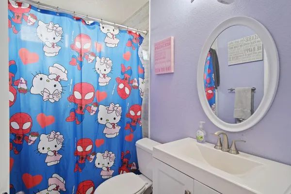 a bathroom with a sink mirror and painting on a wall