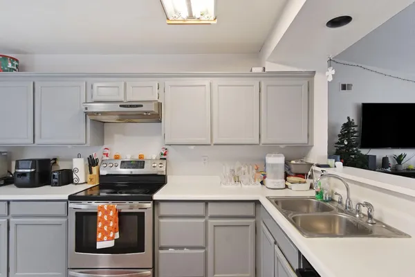 a kitchen with stainless steel appliances a sink stove and cabinets