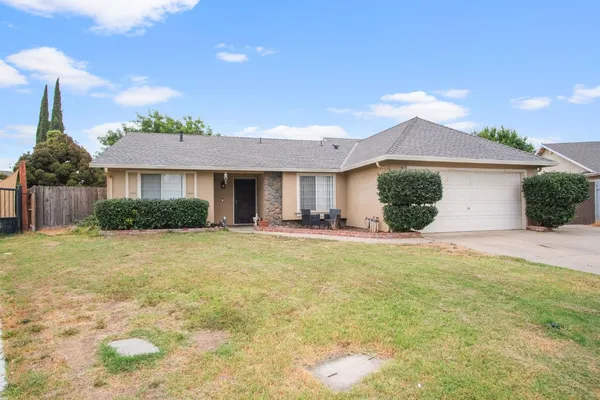 a front view of a house with a garden and yard