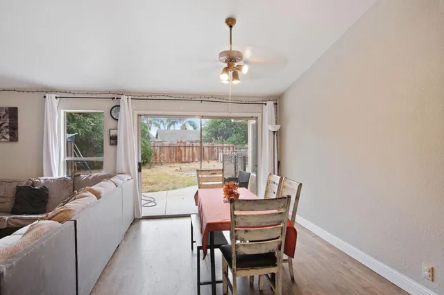 a dining room with furniture a chandelier and wooden floor