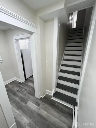 a view of a livingroom with wooden floor and stairs