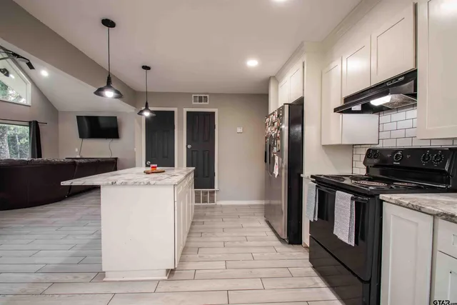 a kitchen with a stove a refrigerator and a microwave