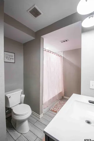a bathroom with a toilet a sink and shower