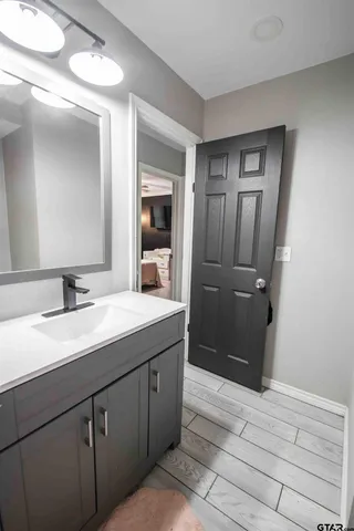 a bathroom with a granite countertop sink and mirror