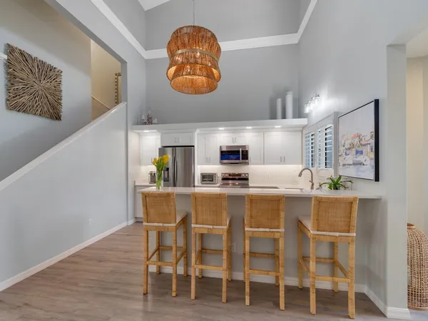 a kitchen with a dining table chairs and cabinets
