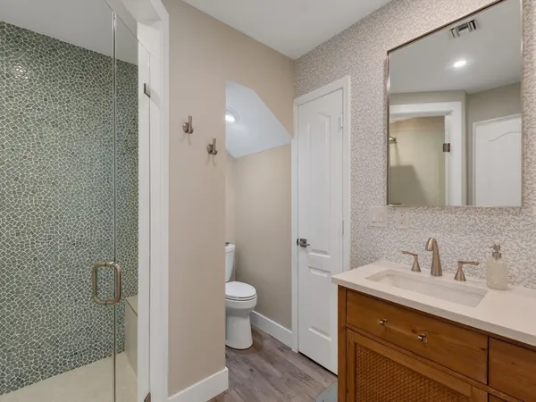 a bathroom with a sink a toilet and shower