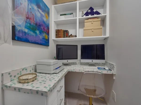 a bathroom with a granite countertop sink and a painting on the wall
